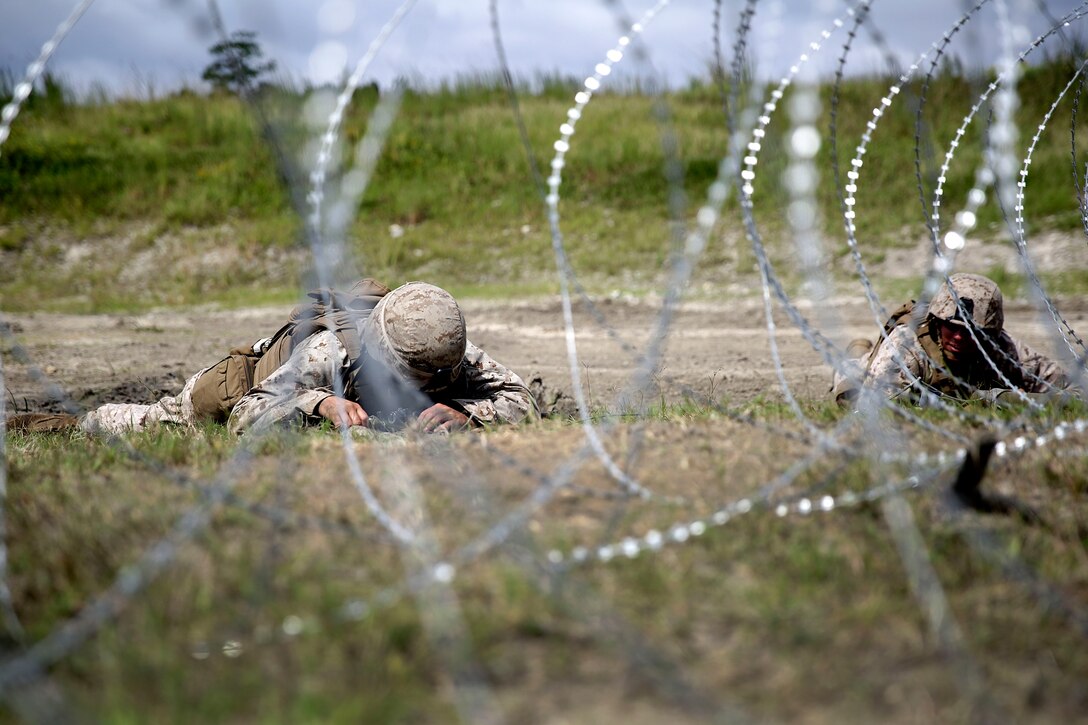 Marines lay in the prone position while they set up a Bangalore charge to destroy a wire obstacle during a demolitions exercise on Camp Lejeune, N.C., Sept. 22, 2015. U.S. Marine Corps photo by Cpl. Alexander Mitchell