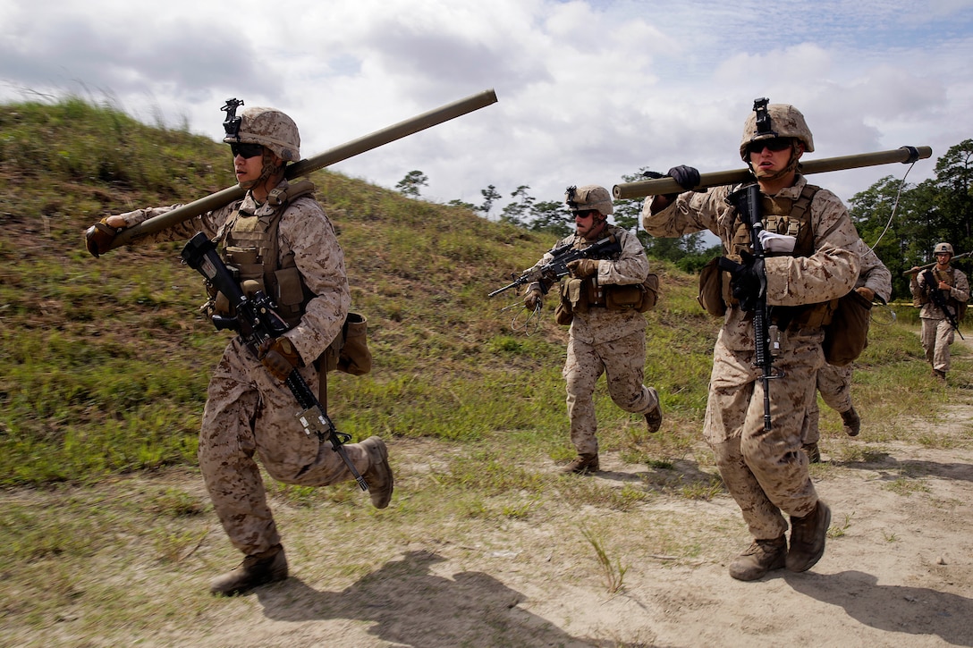 Marines rush to set up a Bangalore charge to destroy a wire obstacle during a demolitions exercise on Camp Lejeune, N.C., Sept. 22, 2015. U.S. Marine Corps photo by Cpl. Alexander Mitchell