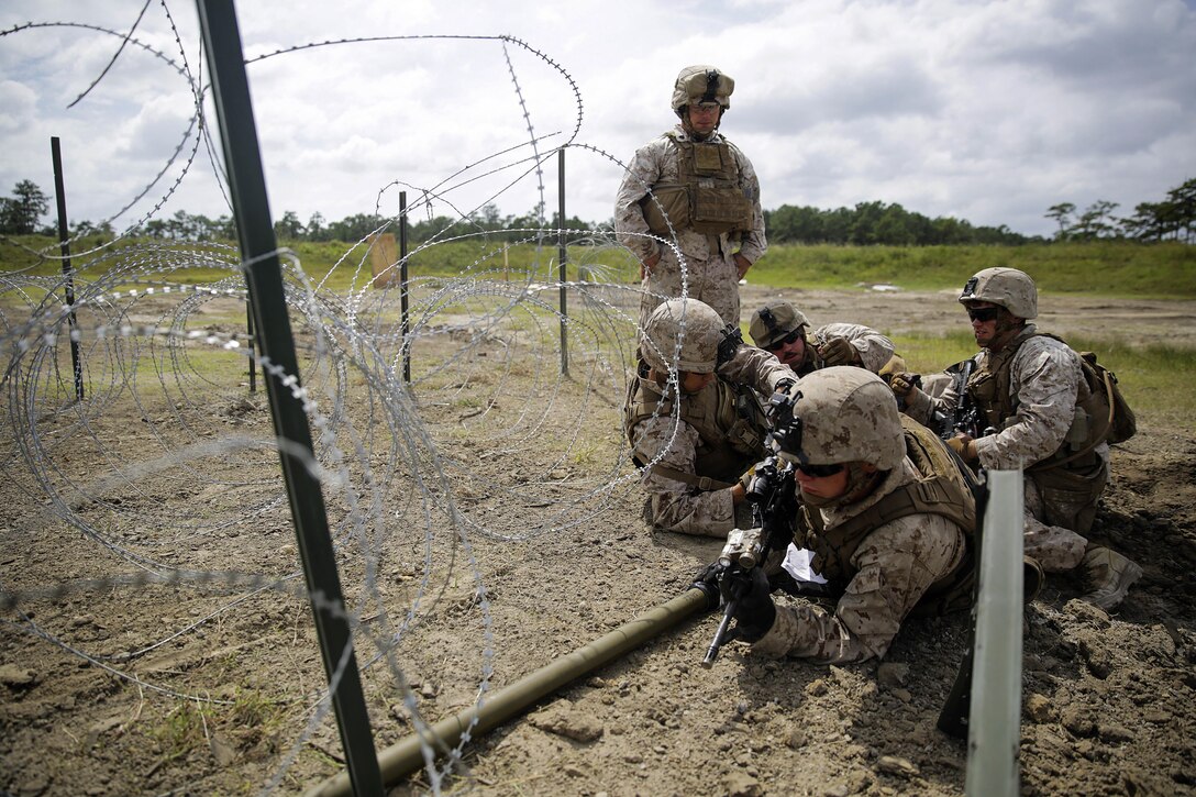 A Marine provides security as his platoon sets up a Bangalore charge to destroy a wire trap during a demolitions exercise on Camp Lejeune, N.C., Sept. 22, 2015. U.S. Marine Corps photo by Cpl. Alexander Mitchell