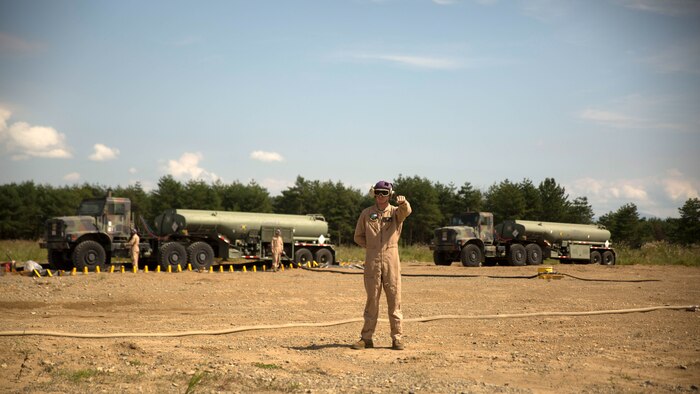 A U.S. Marine with Marine Wing Support Squadron 171 signals a Marine Heavy Helicopter Squadron 462 CH-53E Super Stallion rotary-wing aircraft to hold their position at Aibano Training Area, Sept. 15, 2015. MWSS-171 provided fuel for HMH-462 at a forward arming and refueling point during an assault transport. The assault transport supported a bilateral air assault comprehensive exercise during Forest Light 16-1. FL 16-1 is an exercise to increase interoperability of Japan Ground Self-Defense Force and U.S. Marine Corps forces. MWSS-171 is with Marine Aircraft Group 12, 1st Marine Aircraft Wing, III Marine Expeditionary Force. HMH-462 is with MAG 16, 3rd MAW, currently assigned to MAG 36, 1st MAW, III MEF. 
