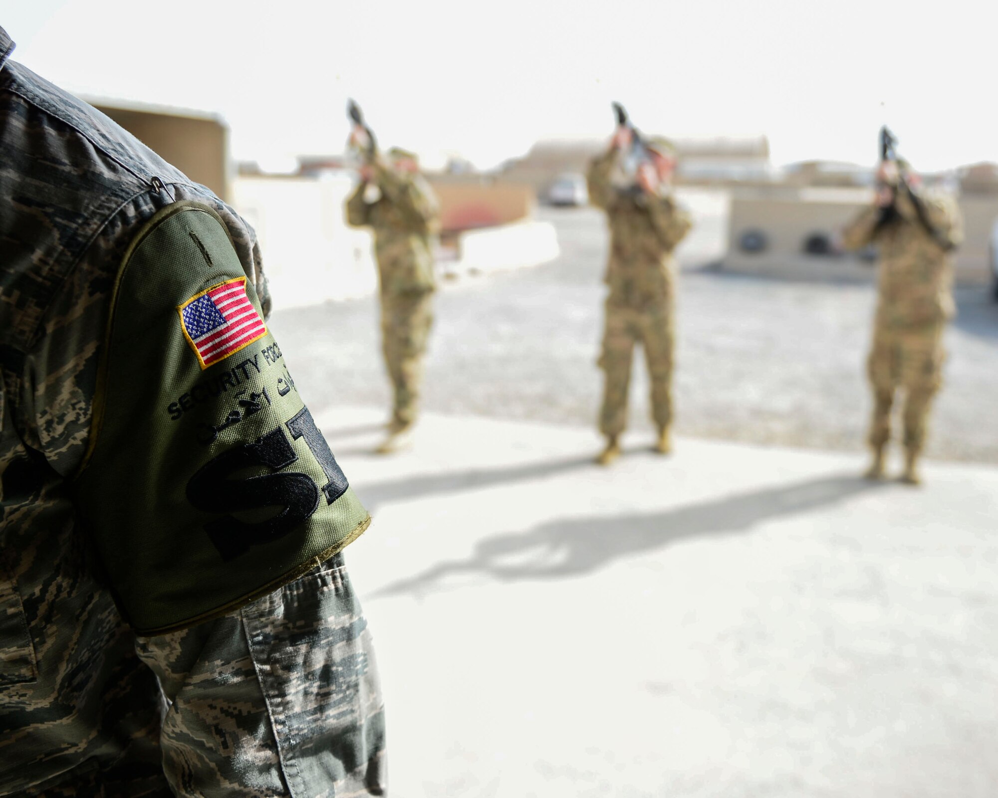 Members of the 386th Expeditionary Security Forces Squadron fire rifle volleys during a battle cross memorial dedication at an undisclosed location in Southwest Asia, Sept. 28, 2015. The dedication took place on the 10th anniversary of Airman 1st Class Elizabeth Jacobson’s death, the first female killed in the line of duty in support of Operation Iraqi Freedom. (U.S. Air Force photo by Senior Airman Racheal E. Watson/Released) 