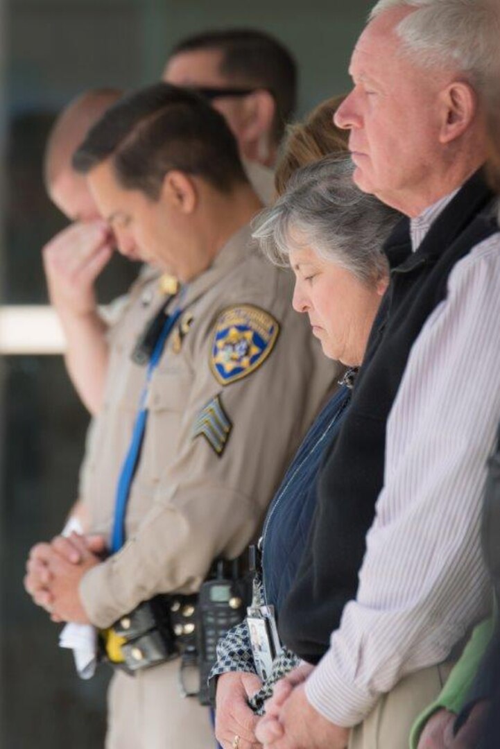Members of the DLA San Joaquin family and local law enforcement reflect in a moment of silence, paying their respects to the fallen officers.