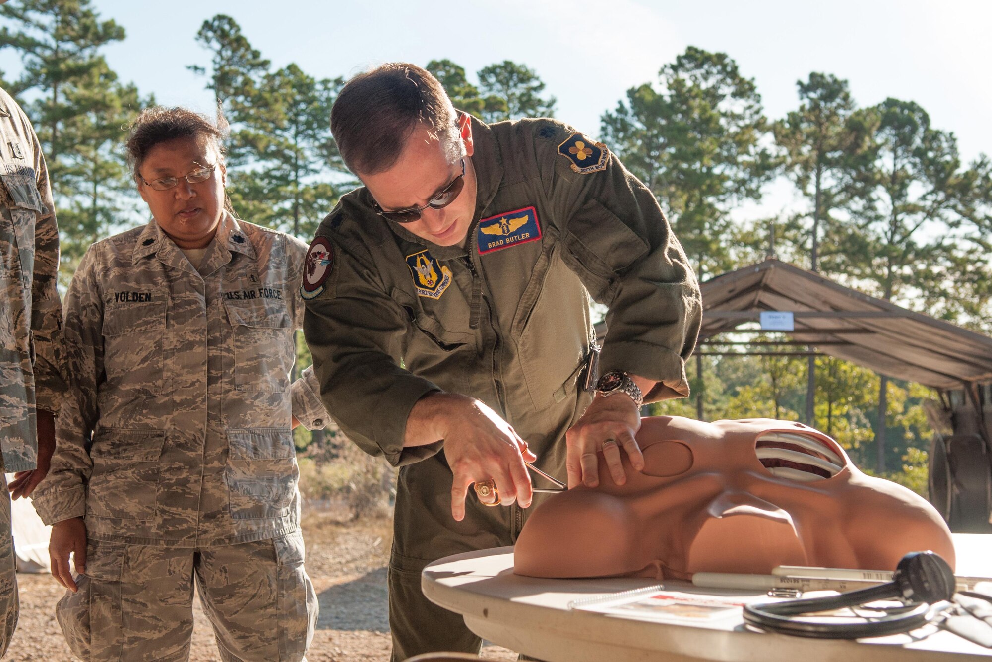 U.S. Air Force Lt. Col. Brad Butler, 307th Medical Squadron, demonstrates how to treat a sucking chest wound to Lt. Col. Sandra Volden, also of the 307th Medical Squadron on Sep. 13, 2015. The medical squadron, along with the 307th Civil Engineer and Services Squadrons participated in a Field Training exercise on the remote “East Reservation” of Barksdale Air Force Base, La. (U.S. Air Force photo by Master Sgt. Dachelle Melville/Released)