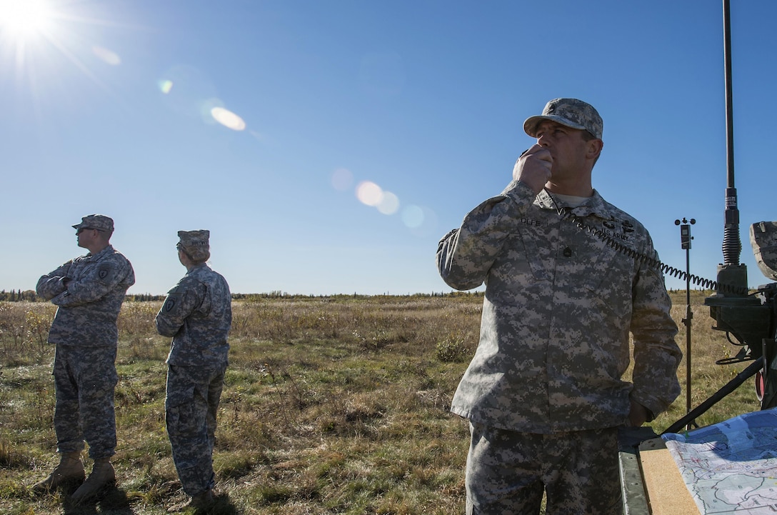 Army Sgt. 1st Class Wolfe, right, communicates with inbound UH-60 Black Hawk helicopters while conducting jump training over Malemute drop zone, Joint Base Elmendorf-Richardson, Alaska, Sept. 24, 2015. Wolfe is a safety officer assigned to the 25th Infantry Division's 4th Infantry Brigade Combat Team, Alaska. The helicopter crew is assigned to the Alaska Army National Guard's 1st Battalion, 207th Aviation Regiment. U.S. Air Force photo by Alejandro Pena