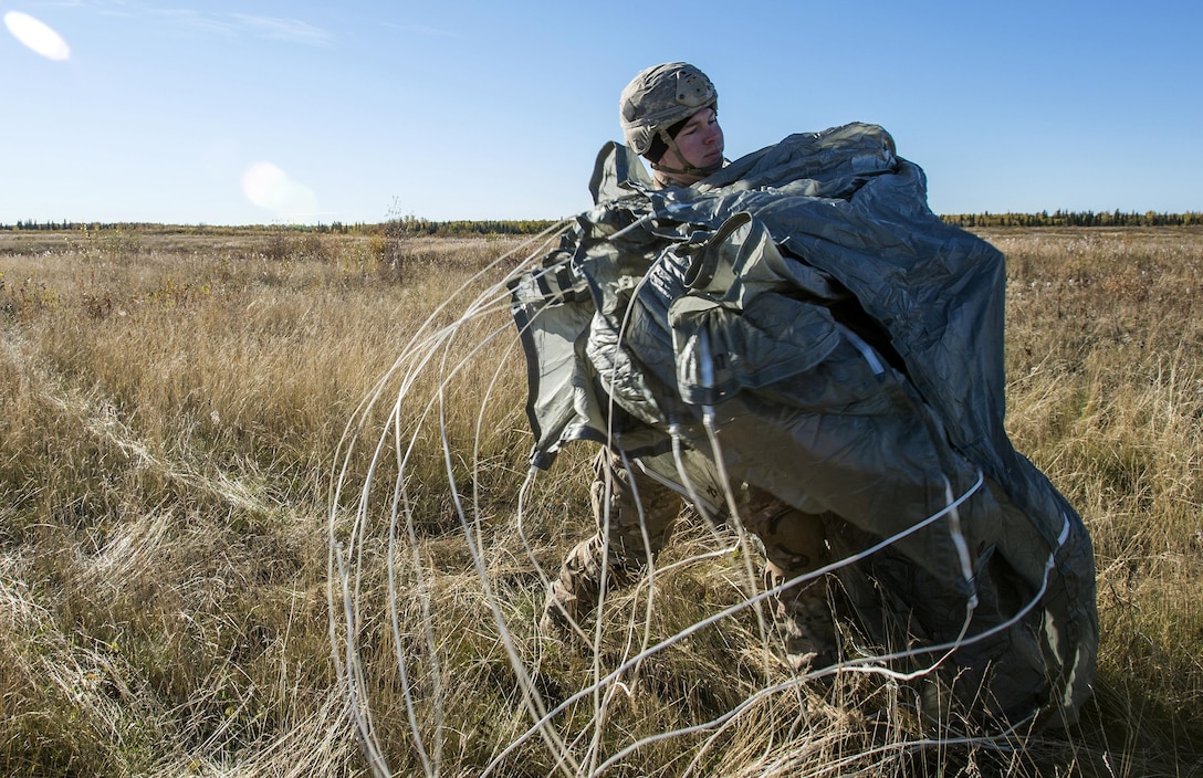 Army Staff Sgt. Walton Lowrey recovers his parachute after conducting a helicopter jump on Malemute drop zone, Joint Base Elmendorf-Richardson, Alaska, Sept. 24, 2015. Lowrey is assigned to Company B, 1st Battalion, Airborne, 501st Infantry Regiment. U.S. Air Force photo by Alejandro Pena
