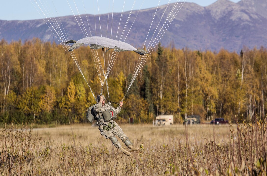 Army Pfc. Robert Manz touches down while conducting helicopter jump training over the Malemute drop zone, Joint Base Elmendorf-Richardson, Alaska, Sept. 24, 2015. Manz is assigned to Headquarters Battery, 2nd Battalion, 377th Parachute Field Artillery Regiment. U.S. Air Force photo by Alejandro Pena 