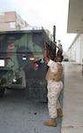 Marine Corps customers drop the sides of a truck so materiel can be unloaded. The Marines are customers of DLA Distribution Yokosuka, Japan, at Okinawa.