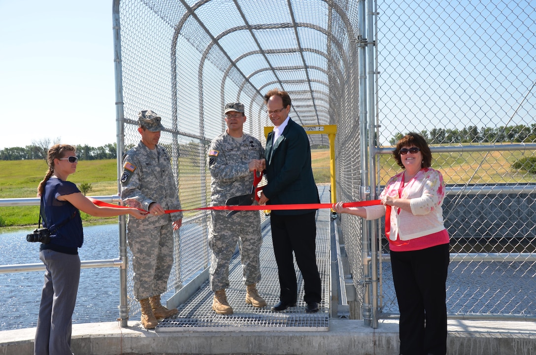 Maj. Gen. John Peabody, Mississippi Valley Division commander, and Todd Sando, North Dakota State Water Commission engineer, dedicate the Tolna Coulee Advance Measures Project with a ribbon cutting ceremony July 19. The 800-foot wide structure is designed to regulate the amount of water that would flow through the coulee.