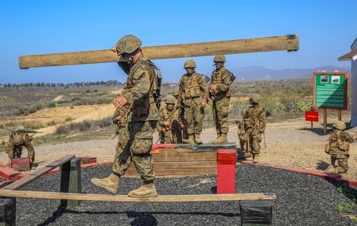 A recruit of Charlie Company, 1st Recruit Training Battalion, crosses wooden planks during the 12 Stalls event at Edson Range, Weapons and Field Training Battalion, Marine Corps Base Camp Pendleton, Calif., Sept. 23.  The challenge required the recruits to cross with their equipment from one point to the other ensuring to avoid the red areas.  Today, all males recruited from west of the Mississippi are trained at MCRD San Diego. The depot is responsible for training more than 16,000 recruits annually. Charlie Company is scheduled to graduate Oct. 2.