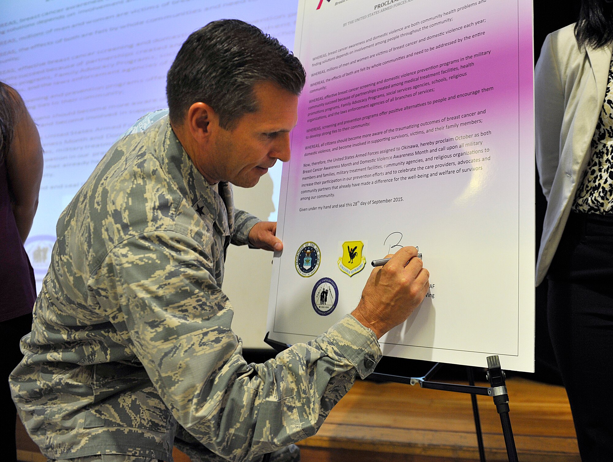 U.S. Air Force Brig. Gen. Barry Cornish, 18th Wing commander, signs a Domestic Violence Awareness and Prevention proclamation board Sept. 28, 2015, on Kadena Air Base, Japan. The proclamation declares the month of October as Domestic Violence Awareness Month, which provides an opportunity for service members and their families to learn more about preventing domestic violence and supporting the various organizations and individuals who assist and advocate for the victims. (U.S. Air Force photo by Naoto Anazawa)