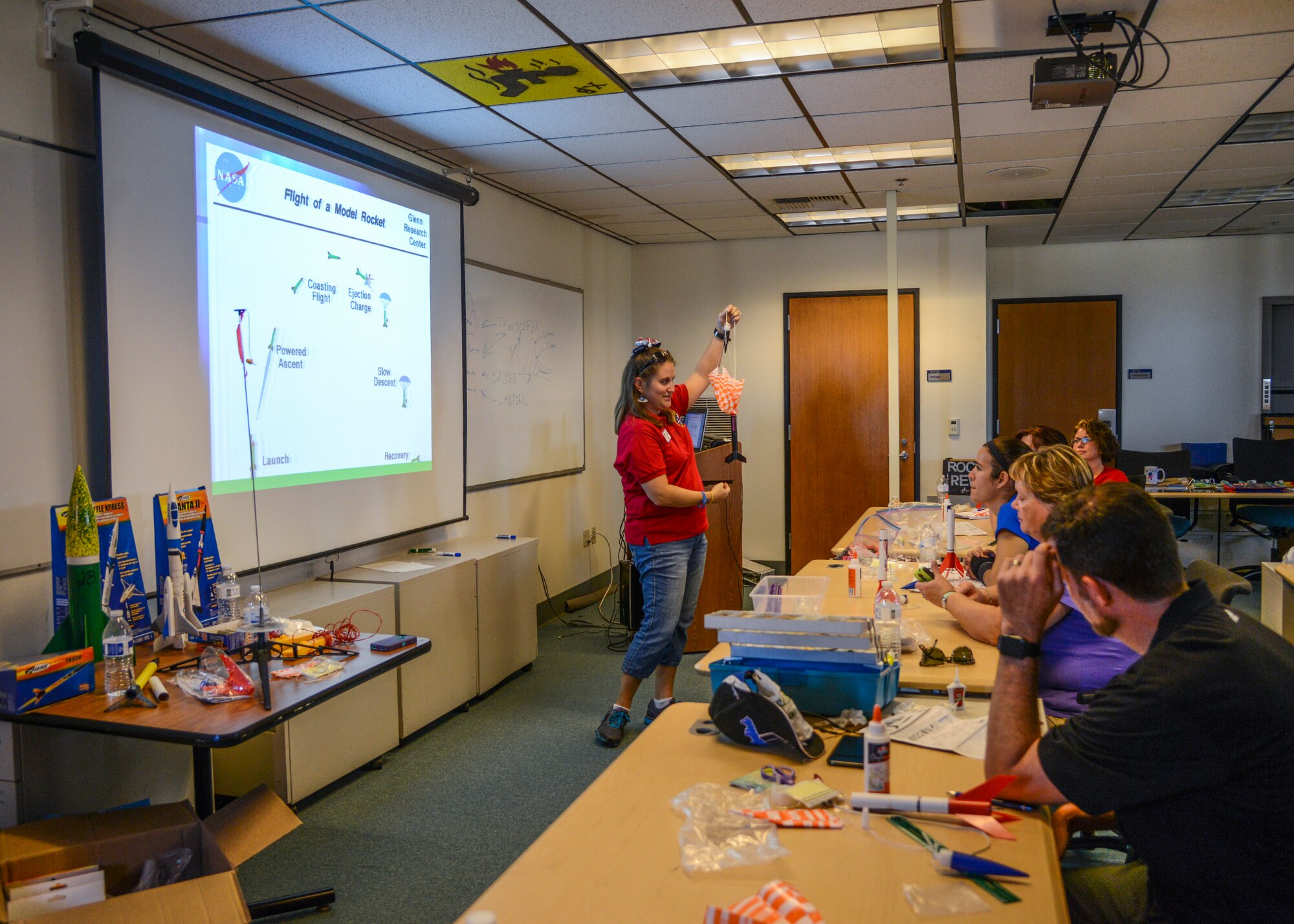 Megan Tucker, workshop coordinator, demonstrates what happens after the rocket launches. (U.S. Air Force photo by Rebecca Amber)