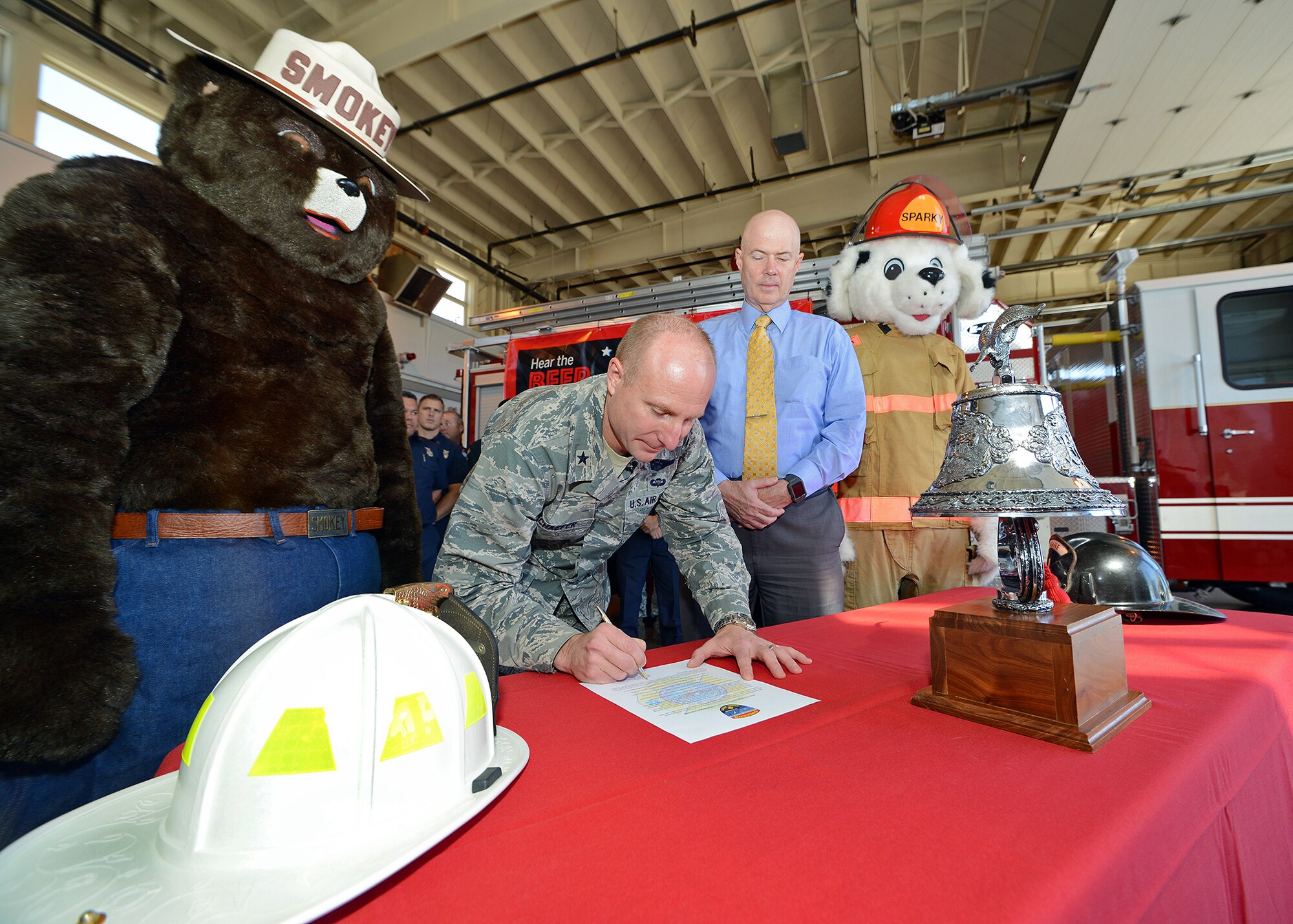 Between Smokey the Bear and Sparky the Fire Dog, Brig. Gen. Carl Schaefer, 412th Test Wing commander, signs this year's Fire Prevention Week Proclamation alongside James Judkins, 412th Civil Engineer Group director, Sept. 18, at Fire Station #2. During Fire Prevention Week the Edwards AFB Fire Department will be providing educational material and information on the leading causes of home fires, information about protecting your home and families with life-saving technologies, and the importance of home escape planning. (U.S. Air Force photo by Jet Fabara)
