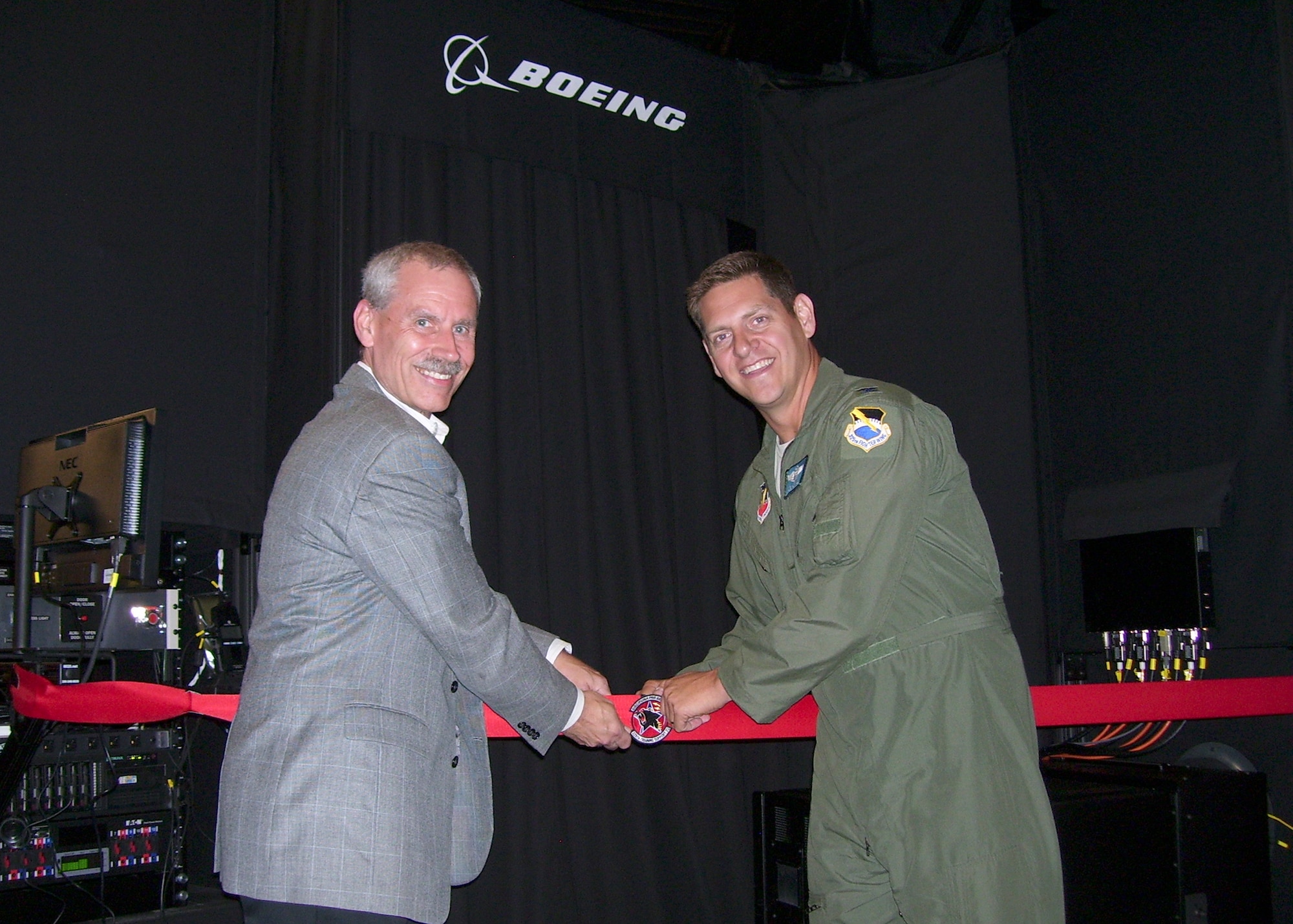 Col. Joseph Kunkel, 325th Fighter Wing vice commander and Randy Diedrick, Boeing director of tactical training systems, attend a ribbon cutting Sept. 24 at the 325th Training Support Squadron for the F-22 Raptor simulator. The ribbon cutting signifies the final installation of the Boeing Constant Resolution Visual System which improves the realism of ground-based training and increases mission readiness for pilots. (U.S. Air Force photo by Airman 1st Class Solomon Cook/Released)