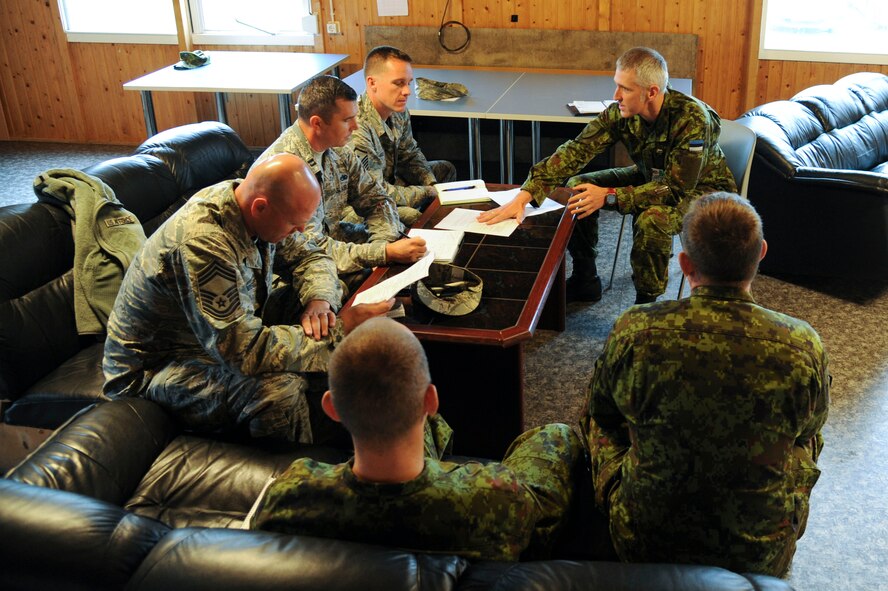 Chief Master Sergeant of the Estonian air force, Janis Jallai, talks to members of the 74th Expeditionary Fighter Squadron leadership about a list of upcoming events during a morale and welfare meeting at Amari Air Base, Estonia, Sept 28, 2015. Every week, leadership from both air forces meet to schedule morale events and discuss opportunities for community service projects.  (U.S. Air Force photo by Andrea Jenkins/Released)