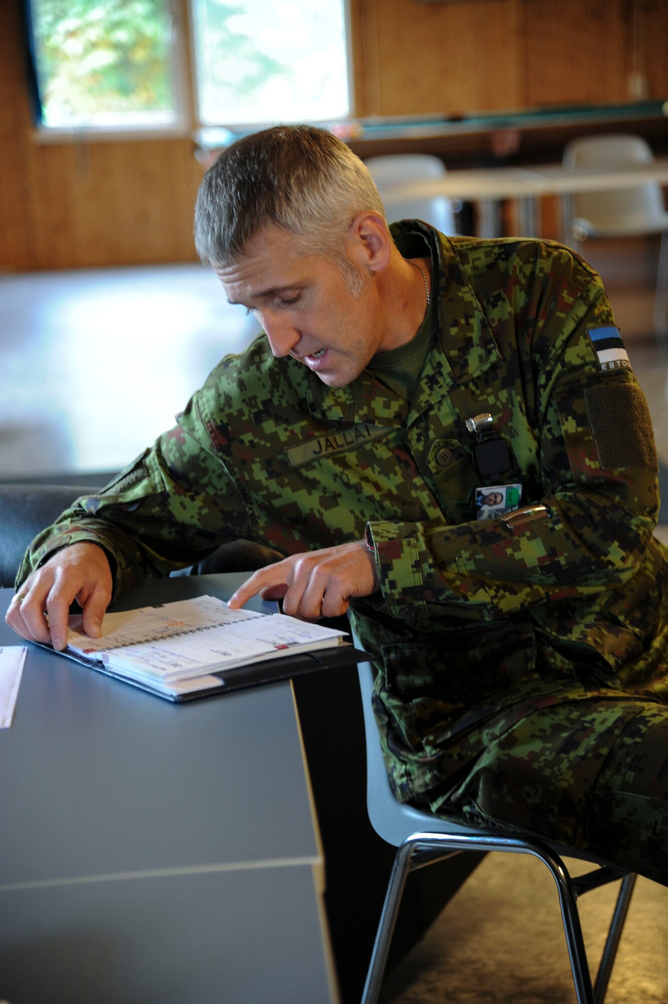 Chief Master Sergeant of the Estonian air force, Janis Jallai, checks his calendar during a morale and welfare meeting at Amari Air Base, Estonia, Sept 28, 2015. Every week, Estonian and U.S. Air Force leadership meet to schedule morale events and community service projects that their Airmen can participate in together.  (U.S. Air Force photo by Andrea Jenkins/Released)