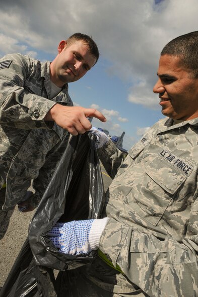 U.S. Air Force Staff Sgt. Oscar Herrin, 74th Expeditionary Fighter Squadron aircraft structural maintenance craftsman, and Senior Airman Guillermo Tersy, 74th EFS metals technology journeyman, perform a foreign object debris walk on the flight line at Amari Air Base, Estonia, Sept. 25, 2015. During a FOD walk, Airmen walk along the flight line looking for debris that could cause damage to aircraft. (U.S. Air Force photo by Andrea Jenkins/Released)