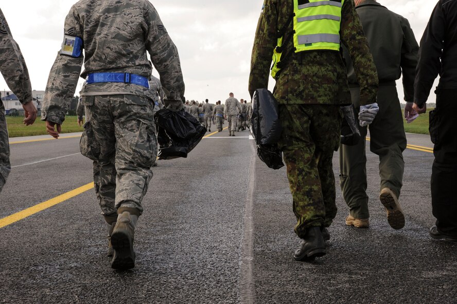 Air Force Airmen assigned to the 74th Expeditionary Fighter Squadron and members of the Estonian air force perform a foreign object debris walk on the flight line at Amari Air Base, Estonia, Sept. 25, 2015. Approximately 350 Airmen from the 23d Wing at Moody Air Force Base, Georgia, will conduct flying training and participate in several exercises with NATO allies over the next several months to strengthen interoperability and demonstrate U.S. commitment to European security and stability. (U.S. Air Force photo by Andrea Jenkins/Released)
