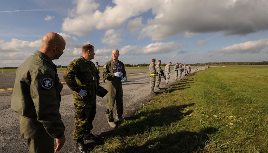 Members of the Estonian air force talk to U.S. Air Force Lt. Col. Bryan France, 74th Expeditionary Fighter Squadron commander before the beginning of a joint foreign object debris walk on the flight line at Amari Air Base, Estonia, Sept. 25, 2015. The combined FOD walk was performed to search for trash and debris that could damage aircraft. (U.S. Air Force photo by Andrea Jenkins/Released)