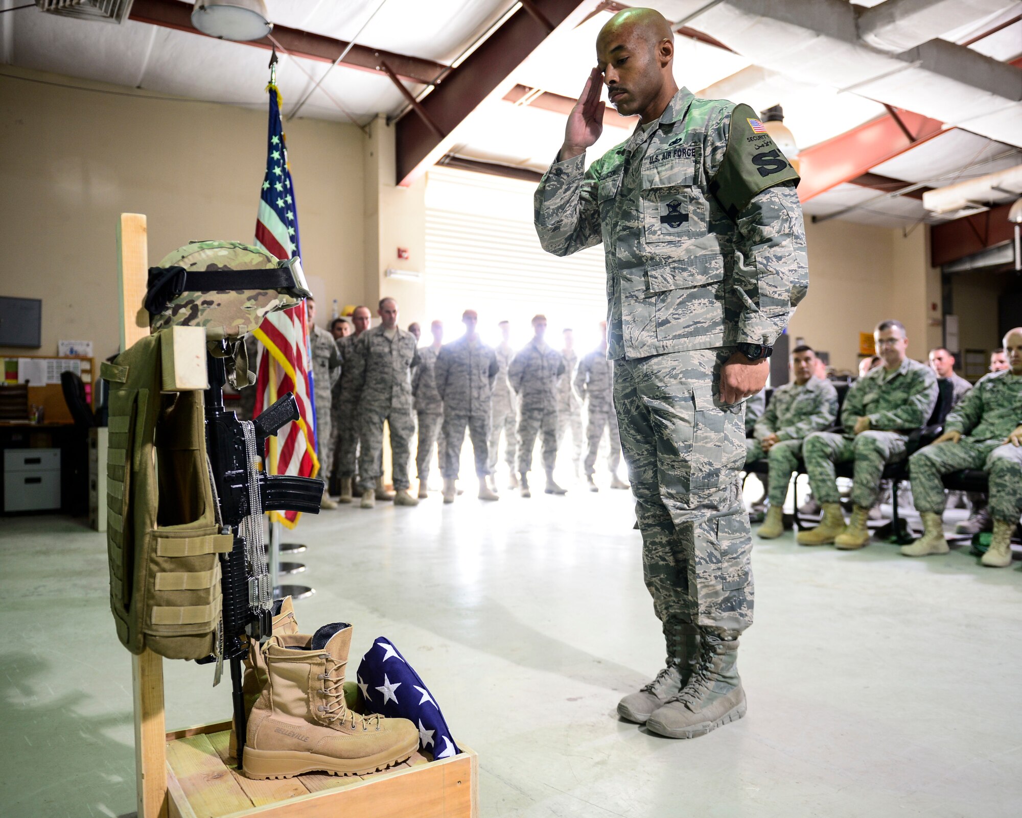 U.S. Air Force Tech. Sgt. Tyreese McAllister, 386th Expeditionary Security Forces honor guardsman, executes a final salute during a battle cross memorial dedication at an undisclosed location in Southwest Asia, Sept. 28, 2015. A rifle pointing down signifies a soldier killed in action, often capped by a helmet and dog tags, and at the bottom, a pair of boots to represent the final march of the last battle. (U.S. Air Force photo by Senior Airman Racheal E. Watson)
