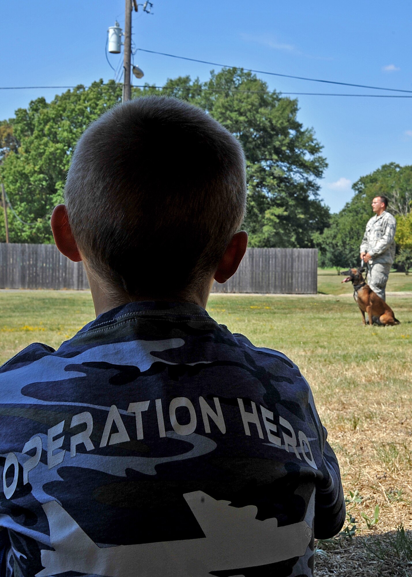 A child watches a military working dog demonstration during Operation Hero at Barksdale Air Force Base, La., Sept. 26, 2015. The annual event let children experience what their parents go through when preparing for a deployment. (U.S. Air Force photo/Senior Airman Joseph Raatz)