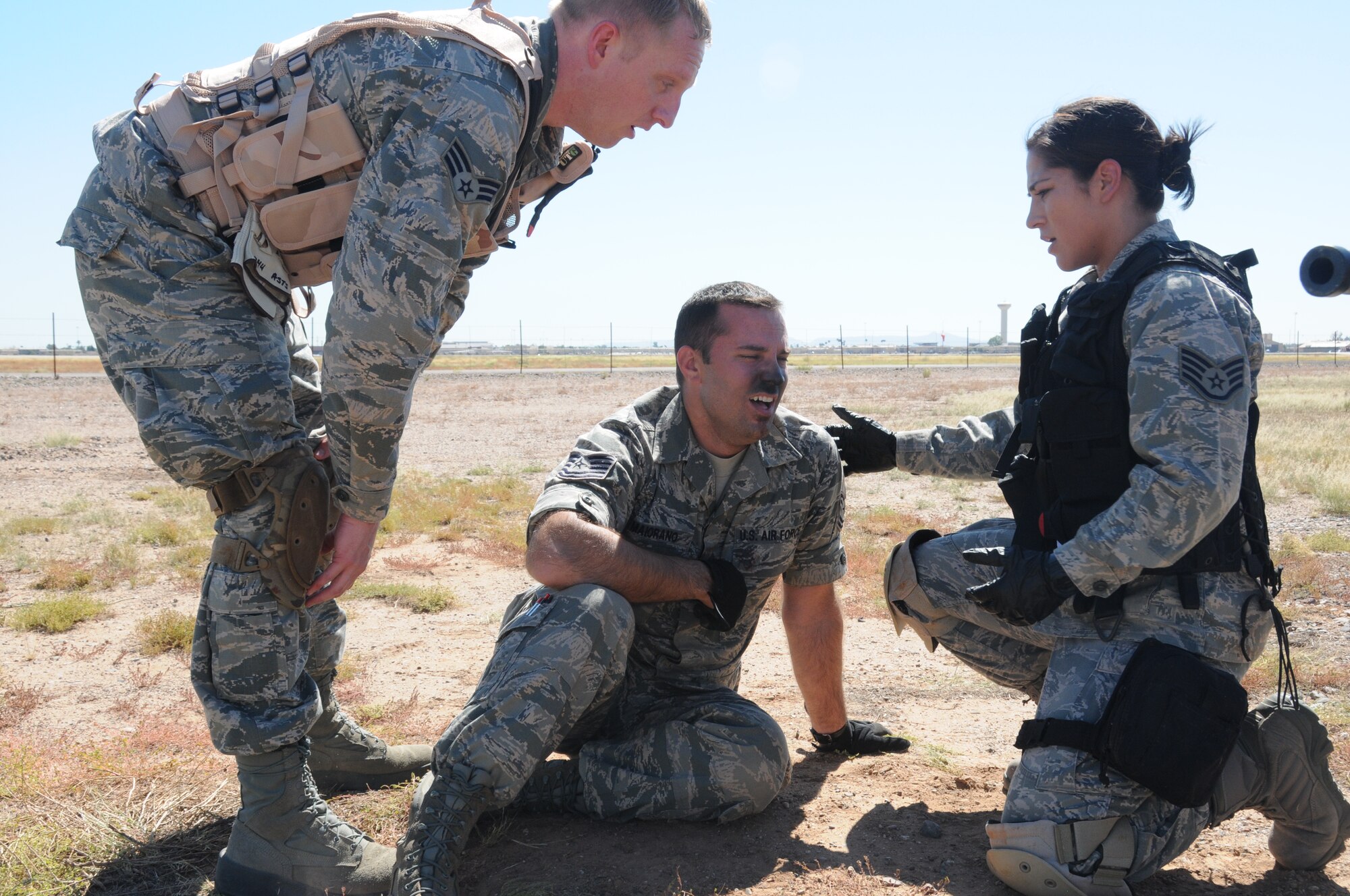 Students render aid to a simulated smoke inhalation casualty during the field training portion of the Tactical Combat Casualty Care Course at Luke Air Force Base, Ariz., September 25. TCCC is an international course that provides education for first responders and offers realistic combat experiences in a tactical environment to prepare for upcoming deployments. (U.S. Air Force photo taken by Staff Sgt. Josh Nason)