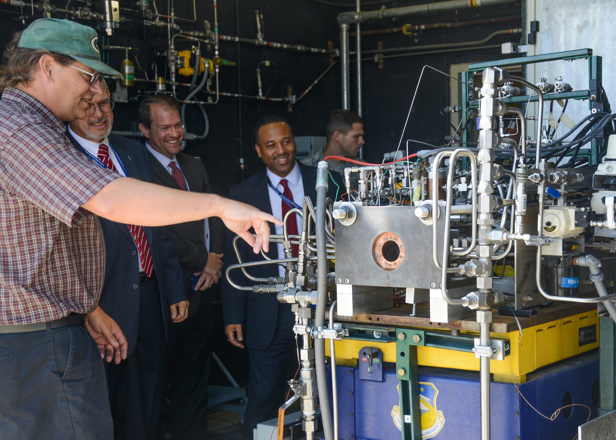 Research scientist Dr. Steve Danczyk, Air Force Research Laboratory, shows Dr. David Walker, a liquid rocket engine test rig used to test individual rocket components prior to scaling them up and integrating them into a full-scale rocket engine. (U.S. Air Force photo by Kenji Thuloweit)
