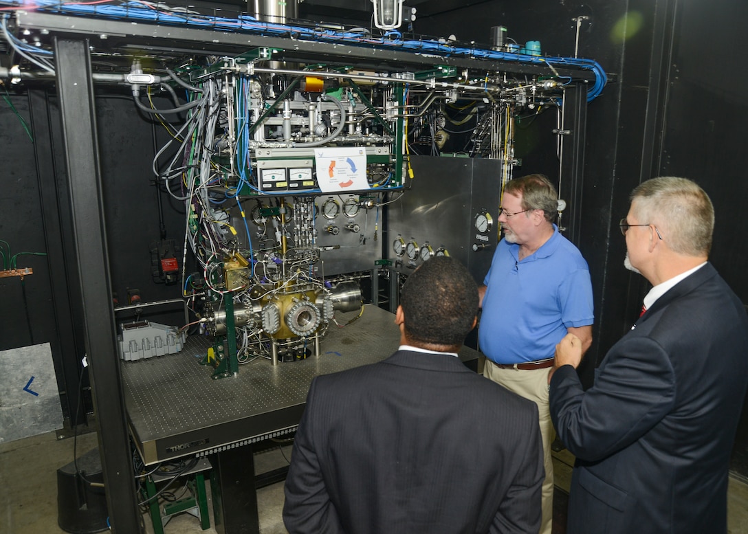 Dr. Doug Talley (blue shirt), Air Force Research Laboratory research scientist, shows Dr. David Walker a test rig used to understand the combustion physics inside a liquid rocket engine during the senior executive's visit Sept. 23. (U.S. Air Force photo by Kenji Thuloweit)
