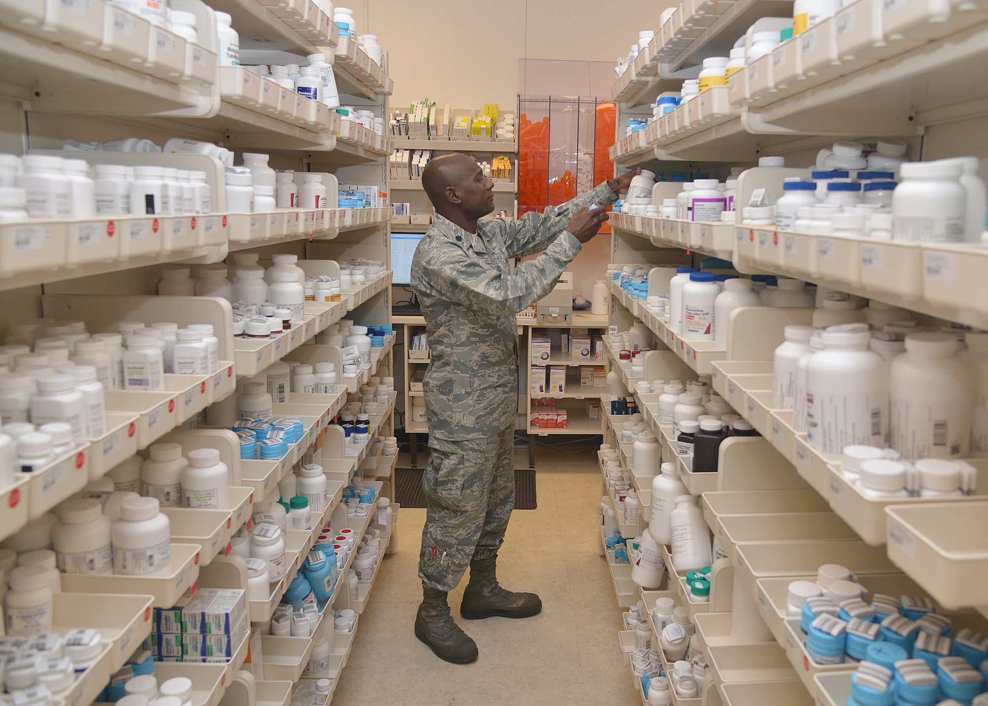 Lt. Col. Derek Larbie, 377th Medical Support Squadron's Pharmacy Flight commander, checks medications at the new pharmacy location at the Base Exchange. The pharmacy, which opens Oct. 26, will use an optimized dispensing process including an robotic automation system in processing about 700 prescriptions daily. (Photo by Todd Berenger)