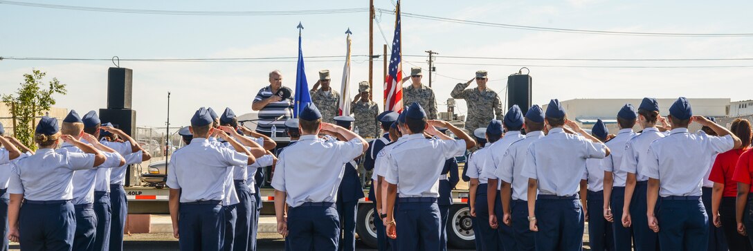 Rosamond High School ROTC and the judges saluted while the Rosamond High School Marching Band played the national anthem to open the parade. The RHS Color Guard presented the colors for the anthem. (U.S. Air Force photo by Rebecca Amber)