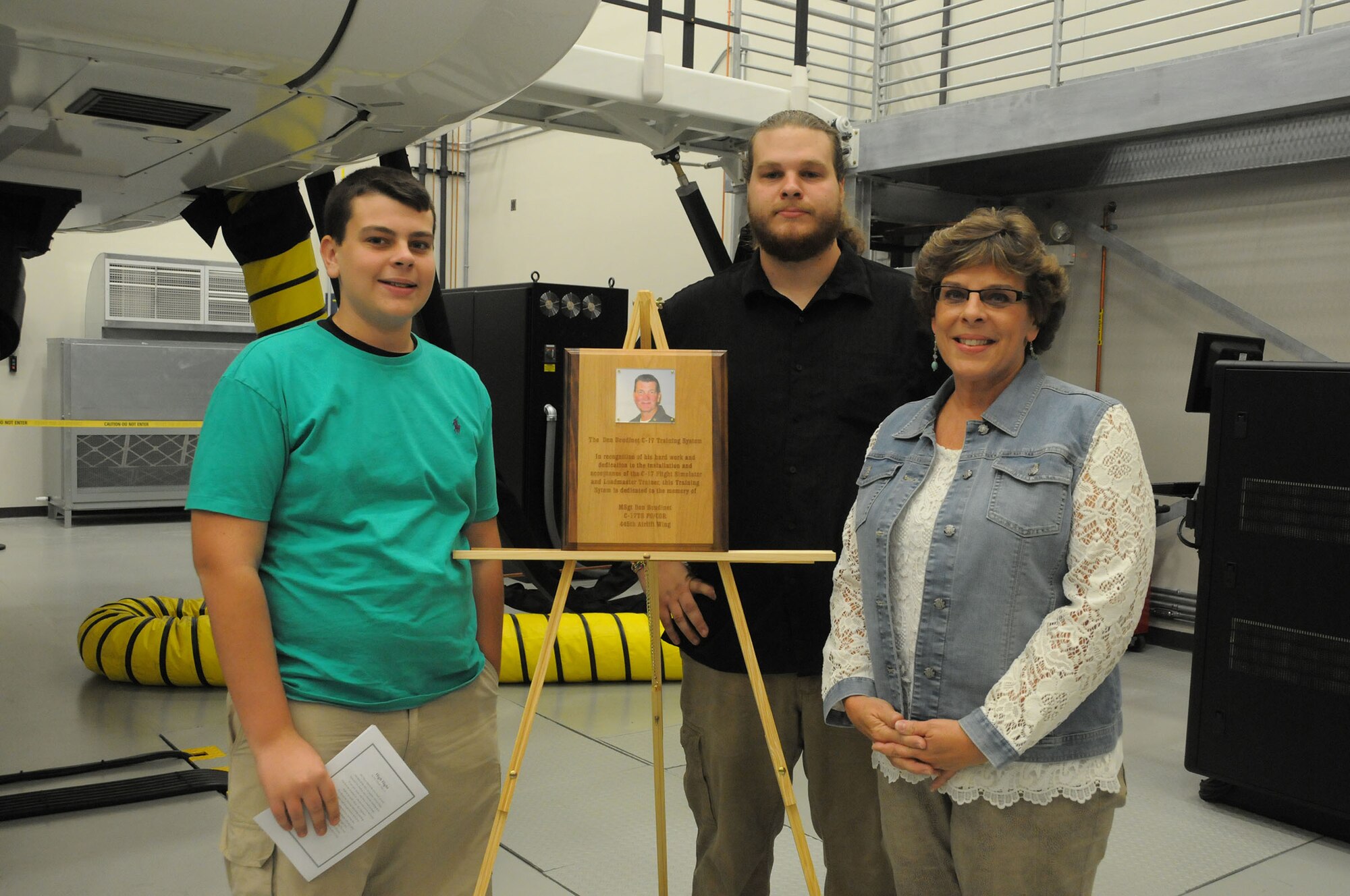 WRIGHT-PATTERSON AIR FORCE BASE, Ohio – A dedication ceremony honoring the late Master Sgt. Don Boudinet, a former 89th Airlift Squadron loadmaster, was held Sept. 12, 2015 at the C-17 Simulator Training Facility here. The Don Boudinet C-17 Training System is dedicated to Boudinet’s hard work and dedication to the installation and acceptance of the C-17 flight simulator and loadmaster trainer. His wife and two sons unveiled a plaque that will be hung in the facility to honor his memory. (U.S. Air Force photo/Tech. Sgt. Anthony Springer)