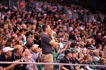 Fans stand up and cheer The University of North Dakota football team as they run a play against the University of California, Davis at the UND Military Appreciation Day event Sept. 26, 2015 in Grand Forks, North Dakota. Guests were treated to a tailgate party ahead of the game, and military members were offered free tickets to see the matchup. (U.S. Air Force photo/Staff Sgt. Susan L. Davis)