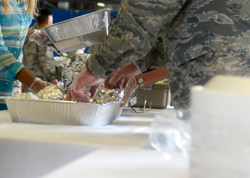Team Shaw members, along with local volunteers, prepare to hand out food during the 7th Annual Military Appreciation Picnic at Shaw Air Force Base, S.C., Sept. 25, 2015. The event provided Team Shaw Airmen and Soldiers with food such as hamburgers and hot dogs. (U.S. Air Force photo by Airman 1st Class Christopher Maldonado/Released)