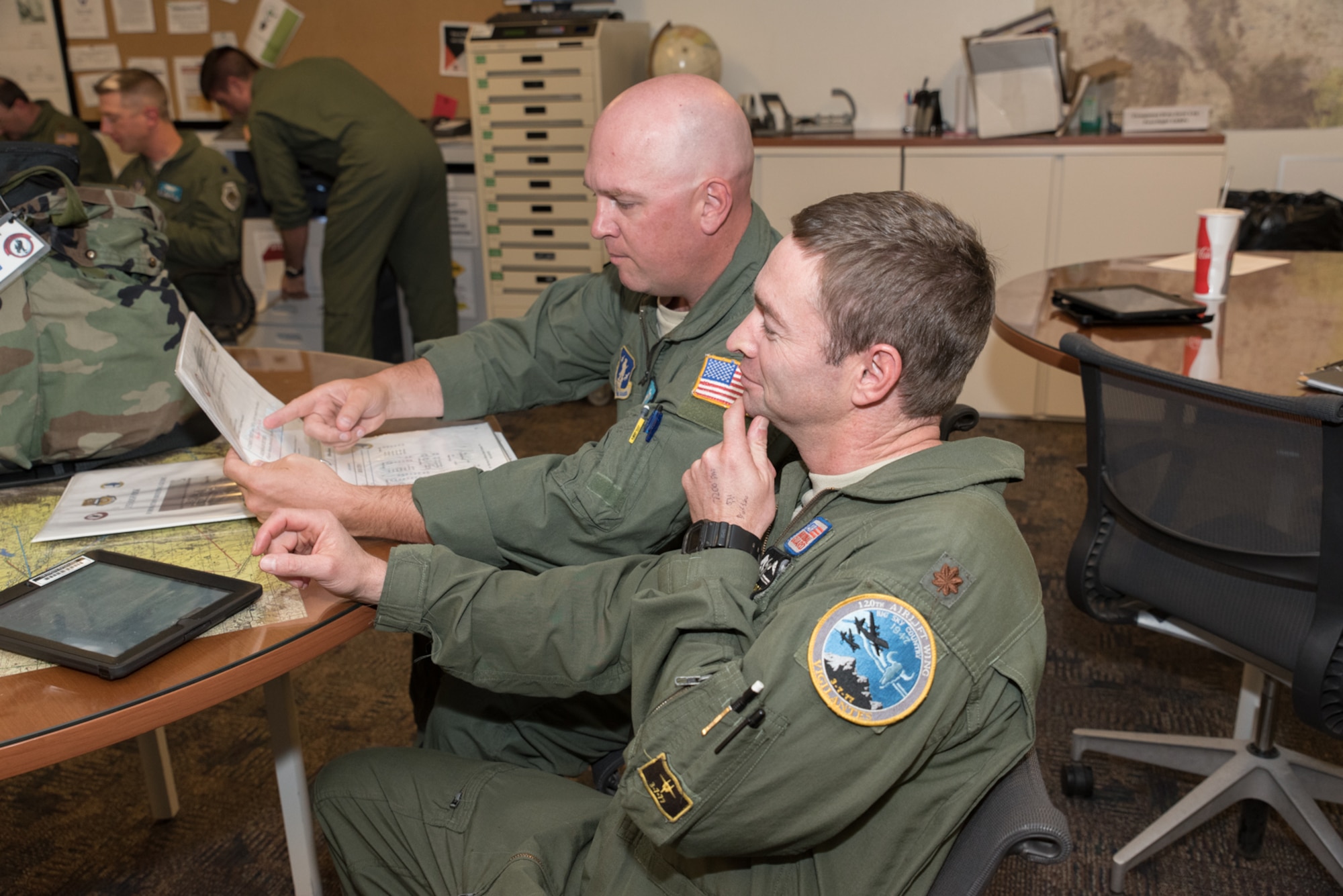 U.S. Air Force Maj. Pat Murphy, 186th Airlift Squadron, Montana Air National Guard, performs flight planning with Maj. Neil Harlow, 187th Airlift Squadron, Wyoming Air National Guard Sept. 23, 2015, in Cheyenne, Wyoming. The two units are collaborating to provide training to the Montana Air National Guard during their conversion from fighter to cargo aircraft. (U.S. Air National Guard photo by Master Sgt. Charles Delano/Released)