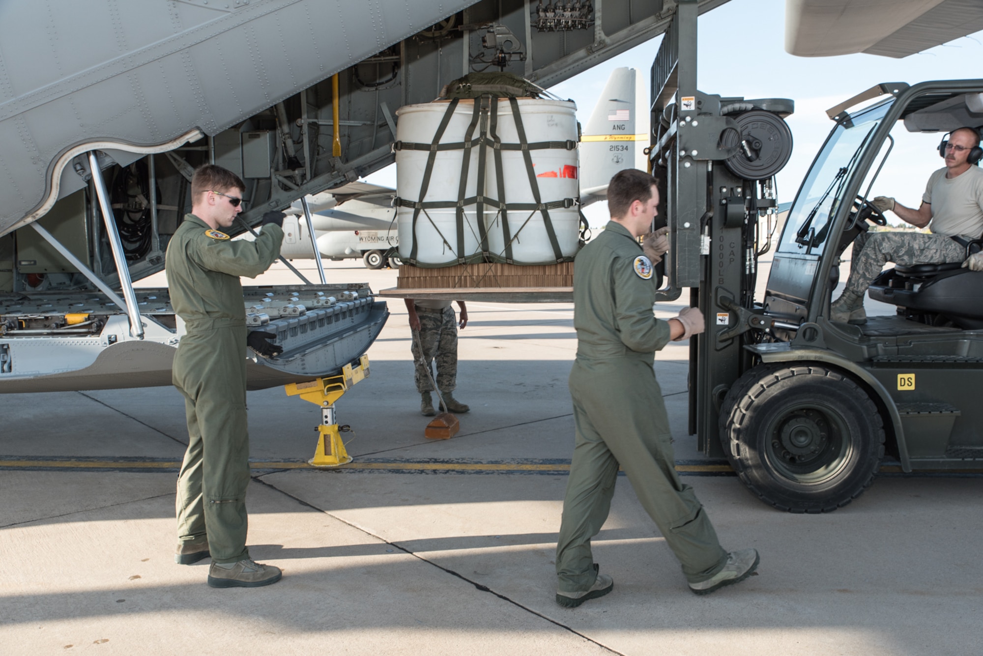 U.S. Air Force loadmasters assigned to the 120th Airlift Wing, Montana Air National Guard work with airmen assigned to the 153rd Logistics Readiness Squadron, Wyoming Air National Guard to load a container delivery system bundle in a C-130H, Sept. 23, 2015, in Cheyenne, Wyoming. The Wyoming Air Guard has been interflying with the Montana Air Guard during their conversion from fighter to cargo aircraft. (U.S. Air National Guard photo by Master Sgt. Charles Delano/Released)