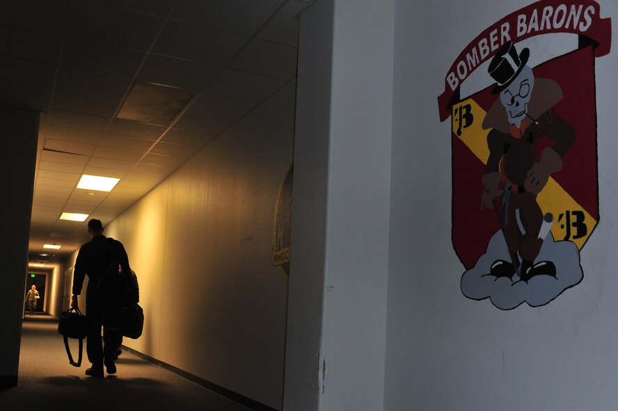 A member of the 69th Bomb Squadron leaves the Pride building for a bombing mission at Minot Air Force Base, N.D., Sept. 23, 2015. The mission took place to ensure the 5th Bomb Wing remains fully capable of providing a full, simultaneous spectrum of devastating global strike options to combatant commanders anywhere, anytime. (U.S. Air Force photo/Senior Airman Stephanie Morris)
