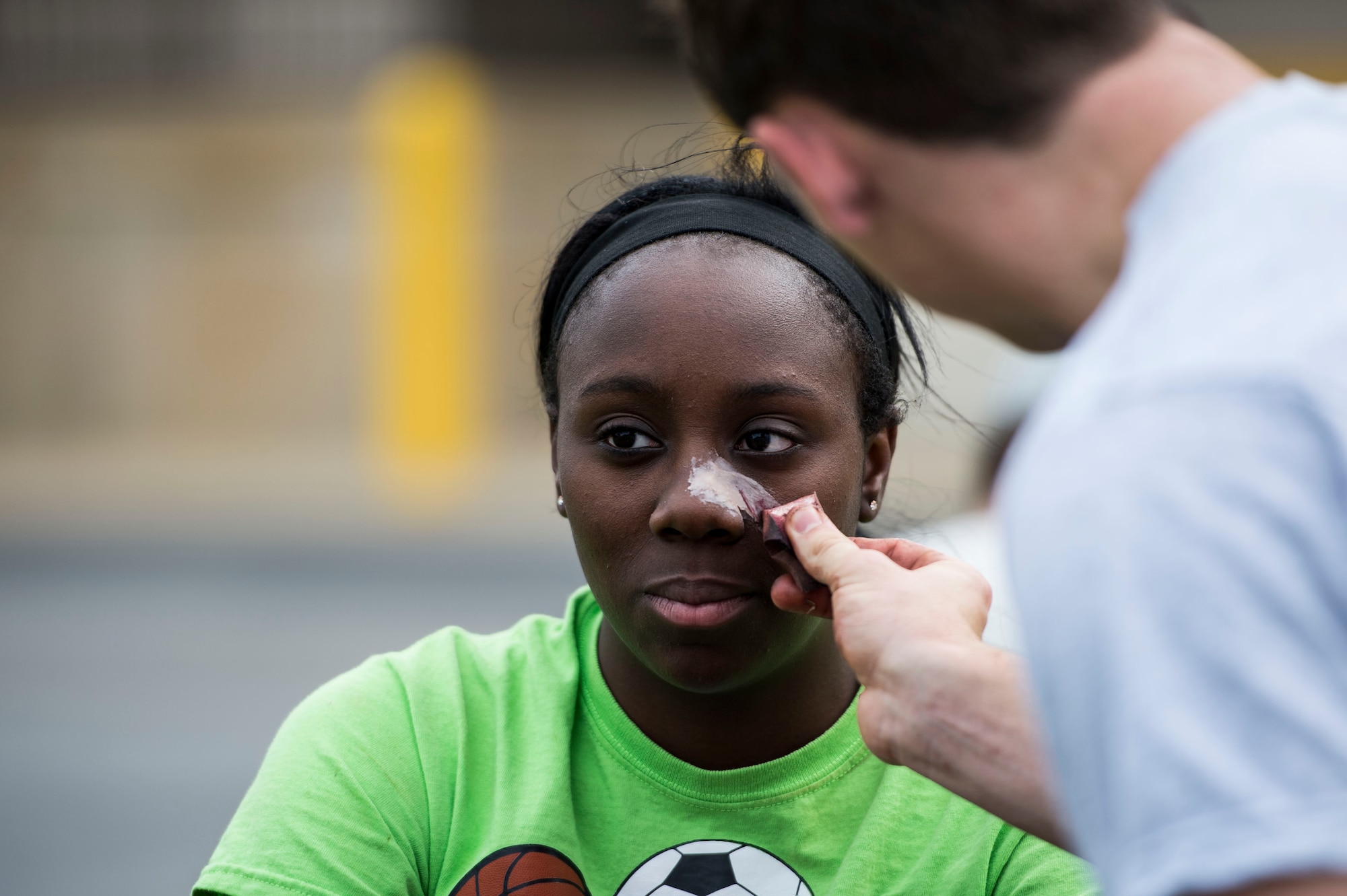 U.S. Air Force Airman 1st Class Shauntol Sims, 633rd Medical Operations Squadron radiology technician, has moulage applied to her face as part of a mass casualty exercise at Langley Air Force Base, Va., Sept. 24, 2015. Moulage enhanced the exercise by providing a more realistic scenario for the Airmen who were tested. (U.S. Air Force photo by Senior Airman Kayla Newman/Released)