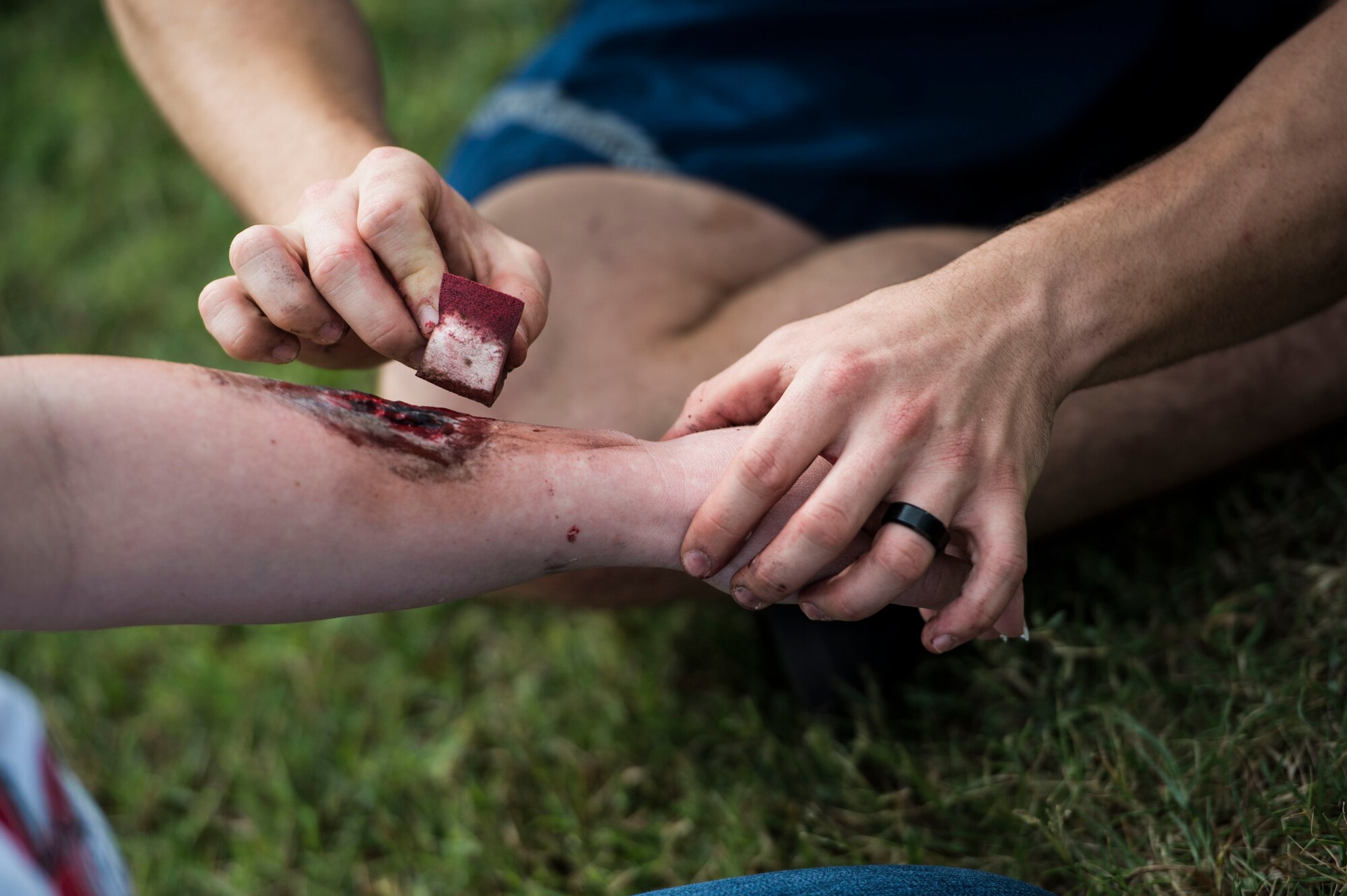 U.S. Air Force Airmen assigned to the 633rd Medical Group apply moulage to simulate realistic injuries during a mass casualty exercise at Langley Air Force Base, Va., Sept. 24, 2015. The exercise tested medical personnel’s readiness in the case of a real-world incident. (U.S. Air Force photo by Senior Airman Kayla Newman/Released)