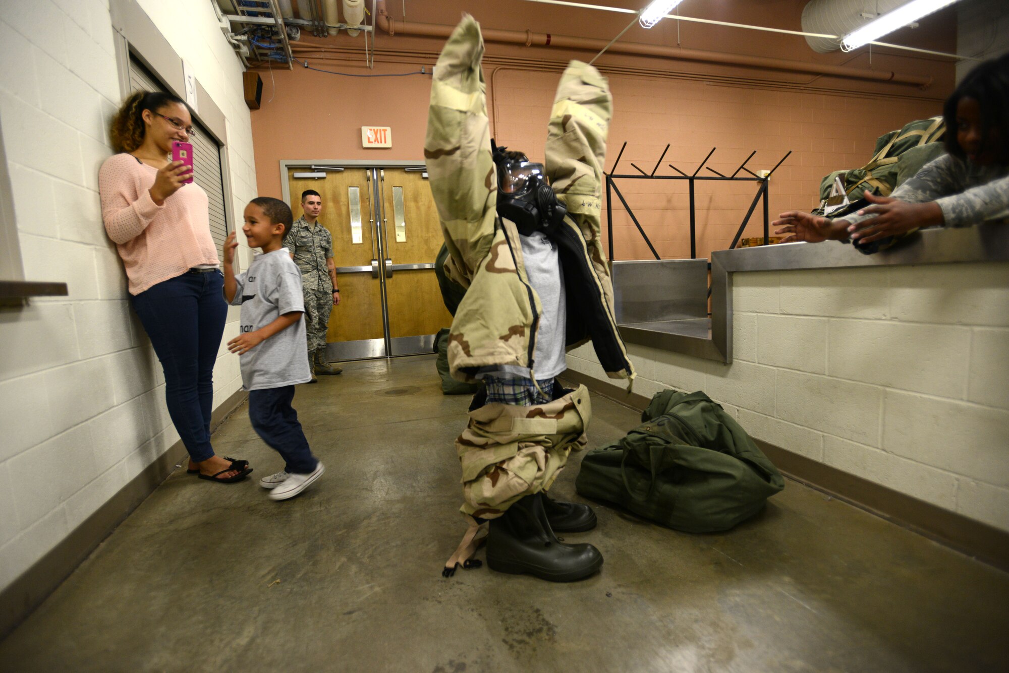 A Team Shaw child tries on Mission Oriented Protective Posture gear at the Chandler Deployment Processing Center during the Kids Meet the Viper event hosted by the 20th Force Support Squadron at Shaw Air Force Base, S.C., Sept. 23, 2015. MOPP gear is designed to protect the wearer from chemical, biological, radiological, and nuclear threats. (U.S. Air Force photo by Airman 1st Class Kelsey Tucker/Released)