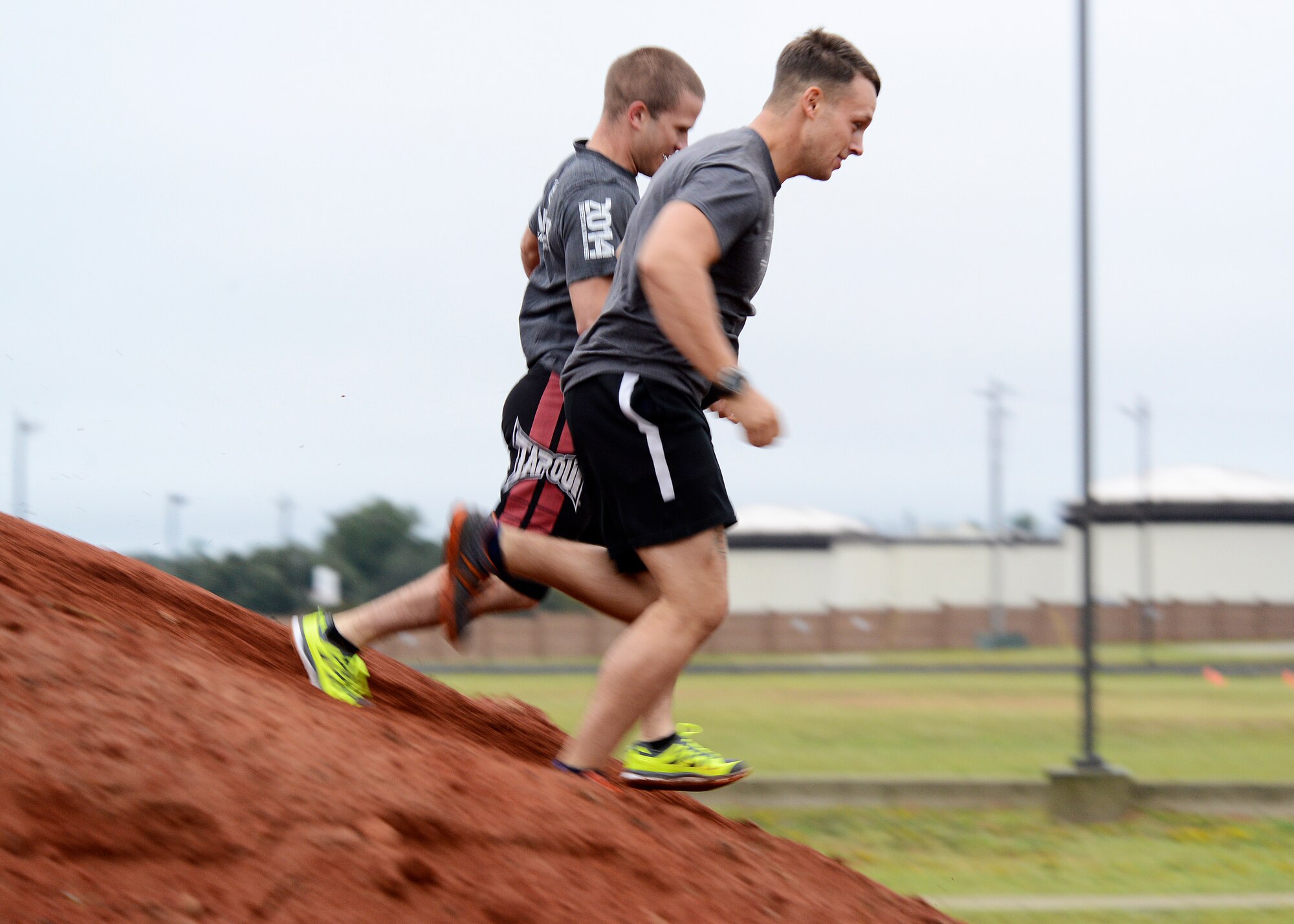 U.S. Air Force Airmen run down a dirt hill during a 20th Fighter Wing Comprehensive Airman Fitness week obstacle course at Shaw Air Force Base, S.C., Sept. 25, 2015. The Airmen participated in varying obstacles throughout the run to test their endurance and resiliency to changing conditions. (U.S. Air Force photo by Airman 1st Class Christopher Maldonado/Released)
