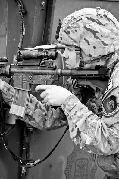 An Airman from the 5th Security Forces Squadron fires a M4 carbine over the hood of a Humvee during a training exercise on the hot cargo pad at Minot Air Force Base, N.D., September 24, 2015. Nine Airmen from the 5th SFS played the role of an oppositional force attempting to overtake the convoy at the cargo pad. (U.S. Air Force photo/Airman 1st Class Justin T. Armstrong)