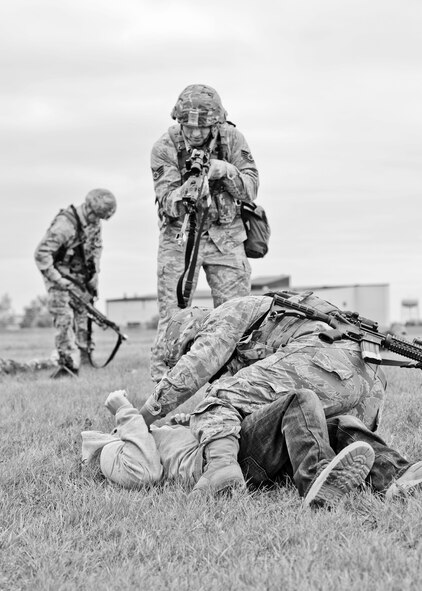 Airmen from the 5th Security Forces Squadron detain and search an Airman role playing as an oppositional force during a training exercise on the hot cargo pad at Minot Air Force Base, N.D., September 24, 2015.  Nine Airmen from the 5th SFS played the role of an oppositional force attempting to overtake the convoy at the cargo pad. (U.S. Air Force photo/Airman 1st Class Justin T. Armstrong)