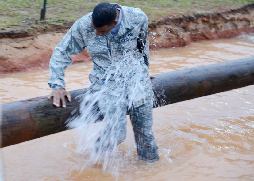 A U.S. Air Force Airman gets hit by a water balloon after falling off a balance log during a 20th Fighter Wing Comprehensive Airman Fitness week obstacle course at Shaw Air Force Base, S.C., Sept. 25, 2015. Airmen volunteers threw the balloons at participants to add further challenges to several of the eight obstacles. (U.S. Air Force photo by Airman 1st Class Christopher Maldonado/Released)