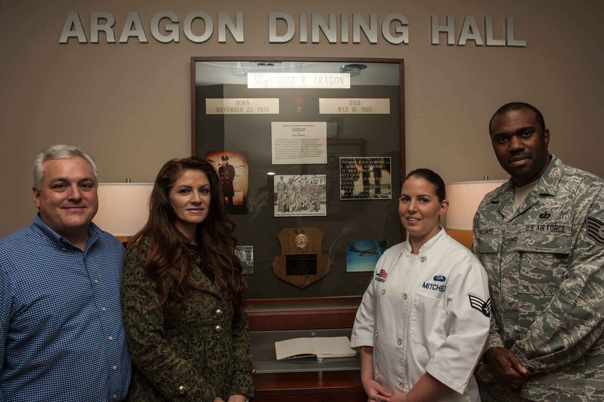 PETERSON AIR FORCE BASE, Colo. – Sandy Aragon Kruse, second from left, poses for a photo with her husband Dominic and two 21st Force Support Squadron Airmen during her visit for a tour of the Aragon Dining Facility, Sept. 25, 2015. Aragon Kruse was visiting the area and toured the facility named after her father for his heroism and sacrifice during the Vietnam War. (U.S. Air Force photo by Airman 1st Class Rose Gudex)