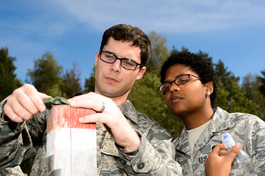 Staff Sgt. Cody Weakland shows Airman 1st Class Sajirah Collazo, both 7th Weather Squadron battlefield weather Airmen, how to operate a compass during a land navigation training Sept. 16, 2015, at Grafenwohr Training Area, Germany. For the first time, the 7th WS is training junior Airmen straight out of technical training on the basics and advance skills needed to operate side-by-side with the Army. (U.S. Air Force photo/Staff Sgt. Armando A. Schwier-Morales)