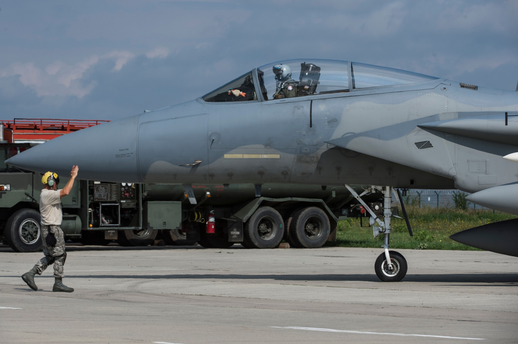 A crew chief from the 123rd Expeditionary Fighter Squadron, 142nd Fighter Wing, Oregon Air National Guard, signals the pilot of an F-15C Eagle fighter aircraft to taxi during a theater security package deployment Sept. 25, 2015, at Campia Turzii, Romania. The aircraft deployed to Romania in support of Operation Atlantic Resolve to bolster air power capabilities while underscoring the U.S. commitment to European security and stability. (U.S. Air Force photo by Staff Sgt. Christopher Ruano/Released)