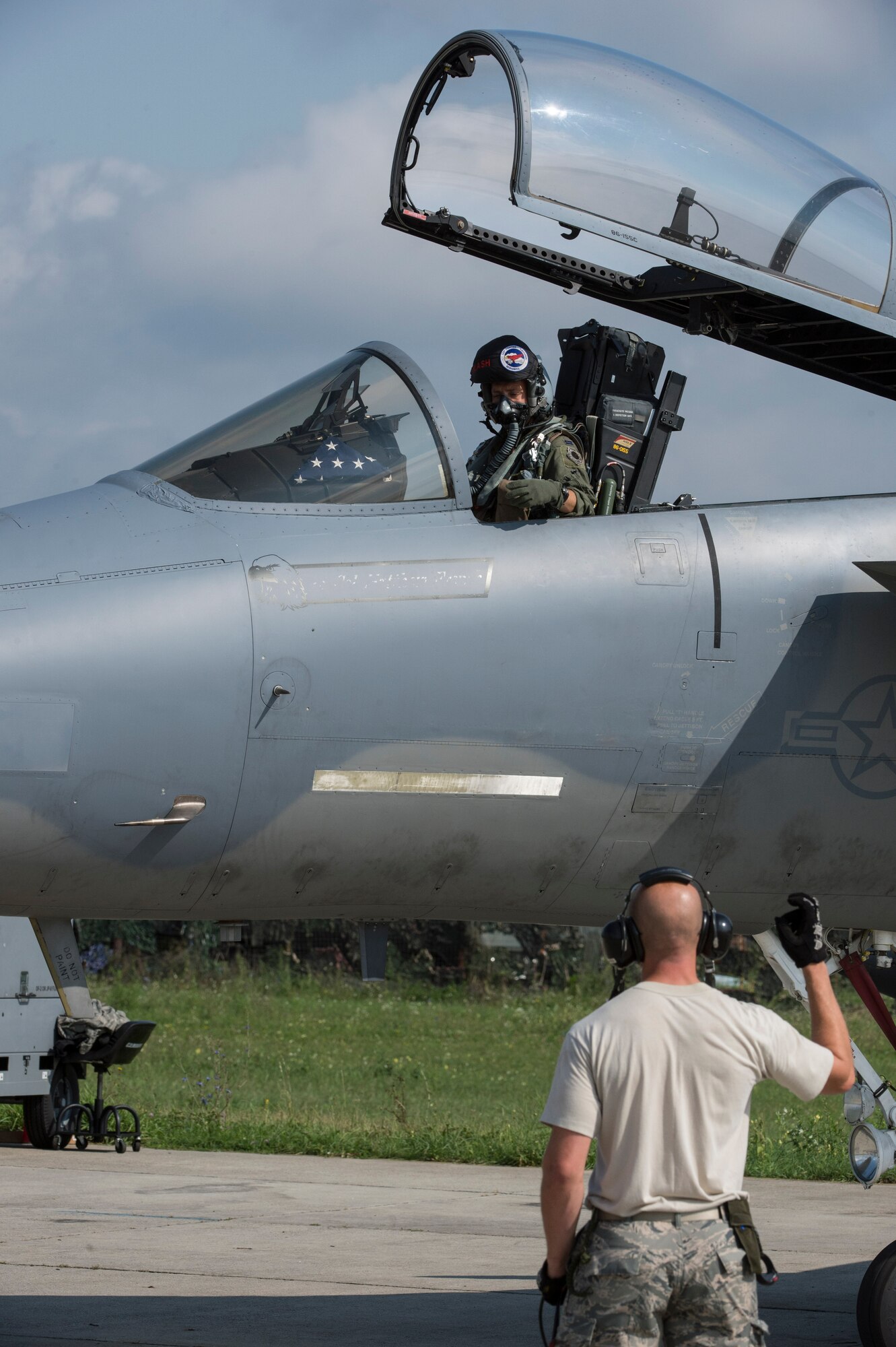 A crew chief from the 123rd Expeditionary Fighter Squadron, 142nd Fighter Wing, Oregon Air National Guard, communicates to the pilot of an U.S. Air Force F-15C Eagle fighter aircraft during a theater security package deployment Sept. 25, 2015, at Campia Turzii, Romania. The aircraft deployed to Romania in support of Operation Atlantic Resolve to bolster air power capabilities while underscoring the U.S. commitment to European security and stability. (U.S. Air Force photo by Staff Sgt. Christopher Ruano/Released)