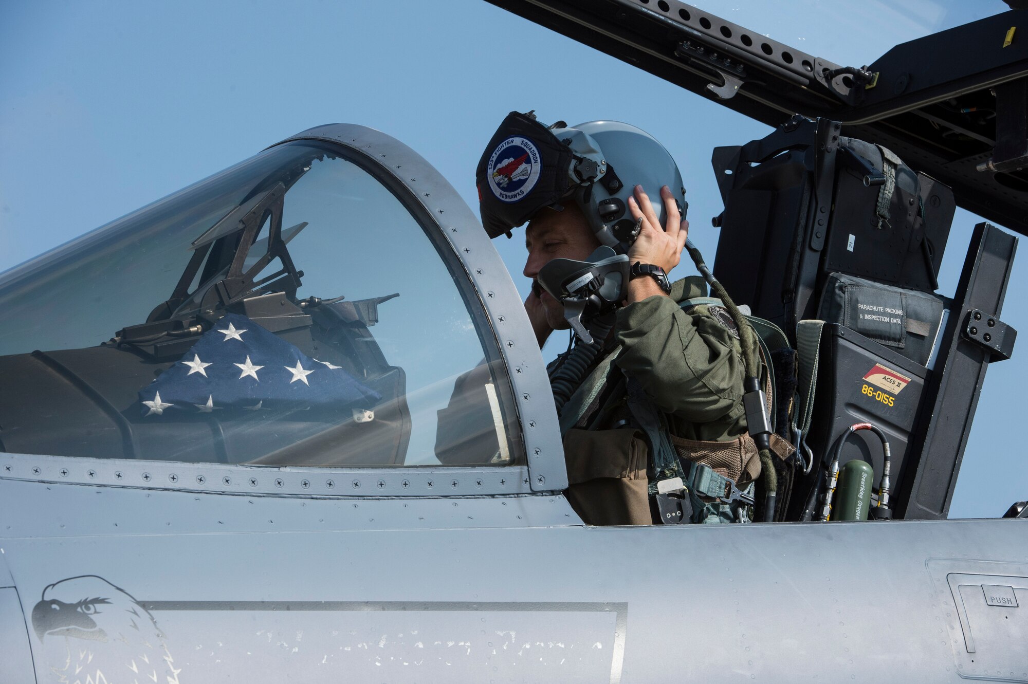 An F-15C Eagle fighter aircraft pilot assigned to the 123rd Expeditionary Fighter Squadron, 142nd Fighter Wing, Oregon Air National Guard, dons his helmet during a theater security package deployment Sept. 25, 2015, at Campia Turzii, Romania. The U.S. Air Force, NATO allies and partners’ continuing contributions to develop and improve air readiness are significant in maintaining security and building partnership capacity. (U.S. Air Force photo by Staff Sgt. Christopher Ruano/Released)