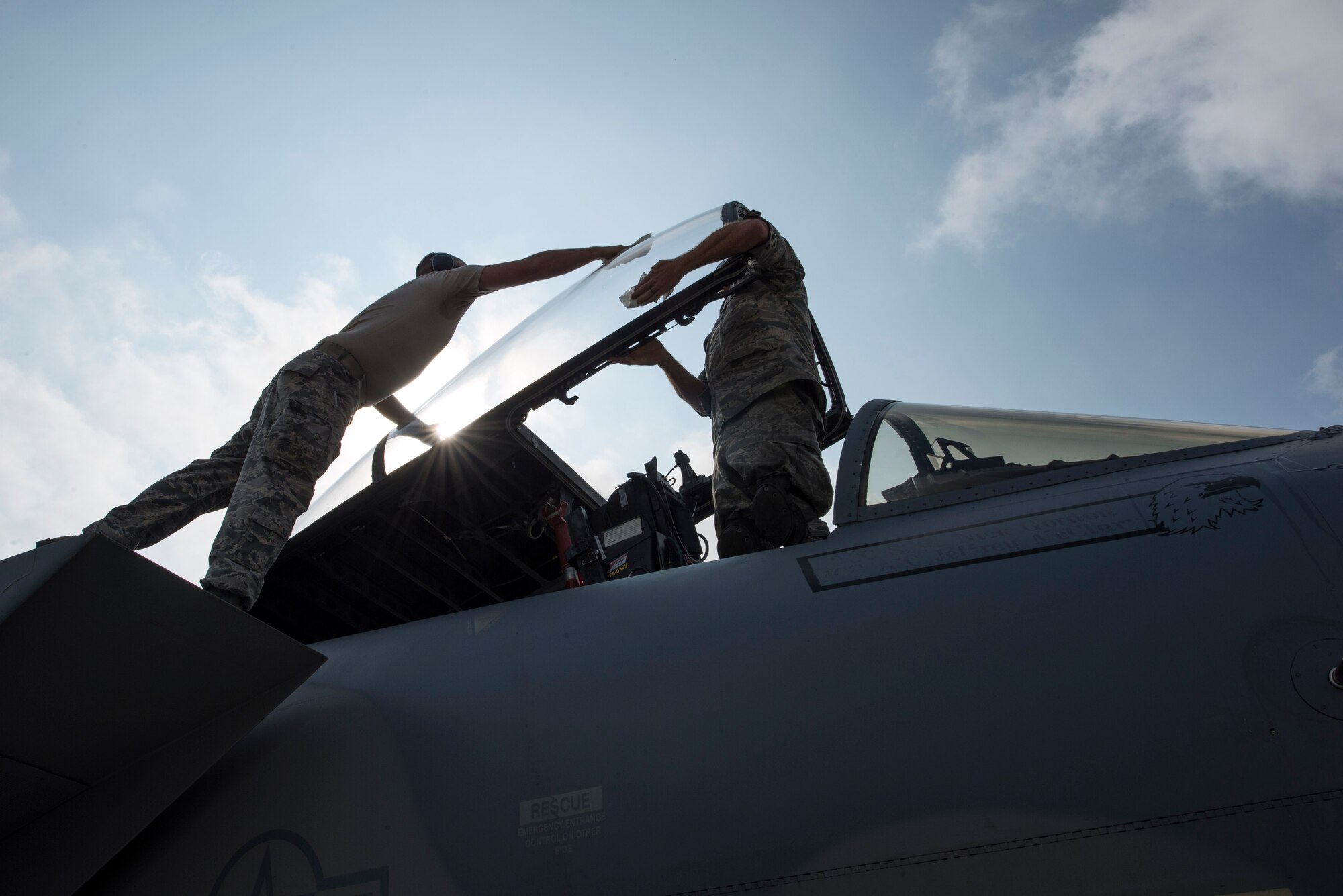 Crew chiefs from the 123rd Expeditionary Fighter Squadron, 142nd Fighter Wing, Oregon Air National Guard, clean the canopy on an F-15C Eagle fighter aircraft during a theater security package deployment Sept. 25, 2015, at Campia Turzii, Romania. The U.S. and Romanian air forces conducted training aimed at strengthening interoperability and demonstrated shared commitment to the security and stability of Europe. (U.S. Air Force photo by Staff Sgt. Christopher Ruano/Released)