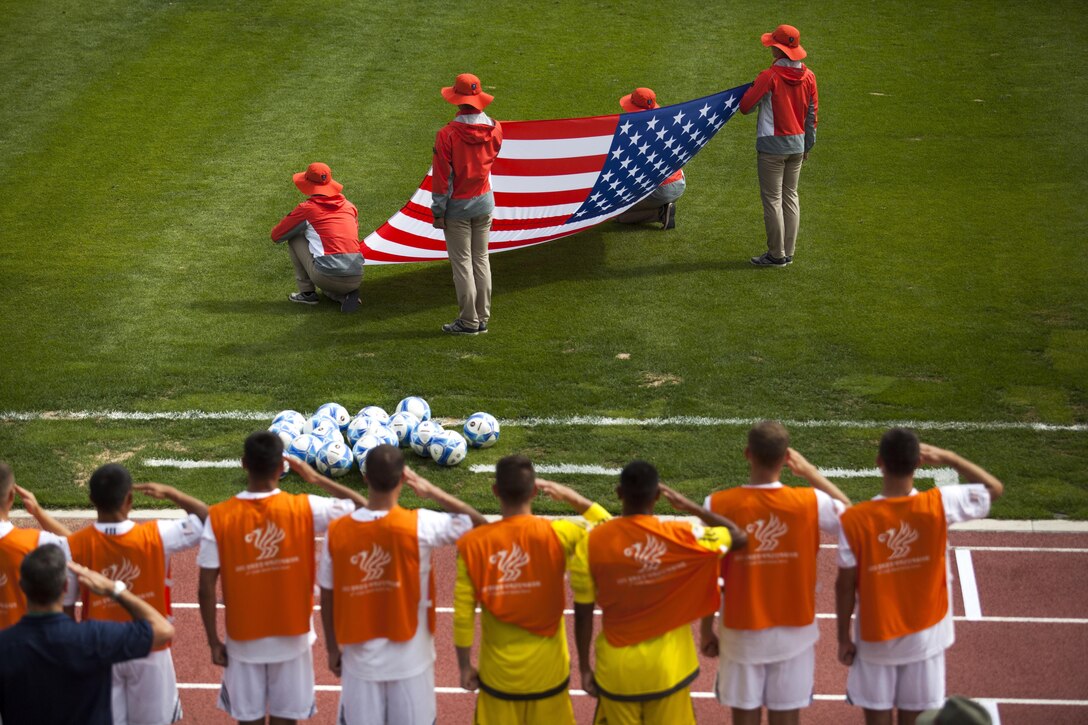 The U.S. men's soccer Team renders honors to the U.S. flag before the opening game against the South Korea men's soccer team during at the 6th CISM Military World Games in Mungyeong, South Korea, Sept. 30, 2015. U.S. Marine Corps photo by Cpl. Jordan Gilbert