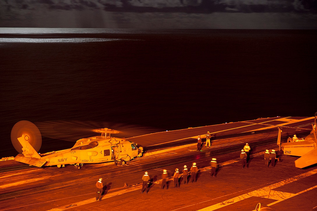U.S. Navy sailors prepare to launch a MH-60R Sea Hawk helicopter assigned to the Proud Warriors of Helicopter Maritime Strike Squadron 72 during night flight operations aboard the aircraft carrier USS Harry S. Truman in the Atlantic Ocean, Sept. 25, 2015. The Harry S. Truman Carrier Strike Group is underway participating in a composite training unit exercise in preparation for a future deployment. U.S. Navy photo by Petty Officer 3rd Class L. C. Edwards